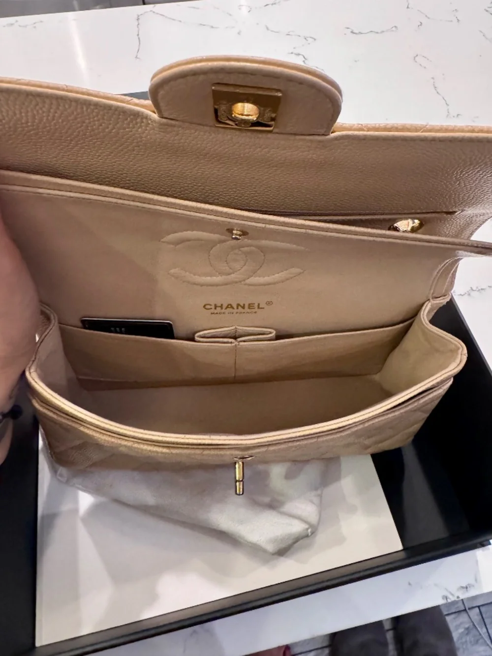 Chanel Classic Medium Double Flap in beige nude caviar with gold tone hardware.